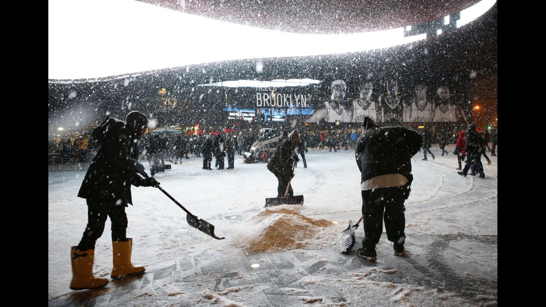 Workers shovel snow in front of Barclays Center in Brooklyn, New York, on January 21 before an NBA game between the Orlando Magic and Brooklyn Nets.