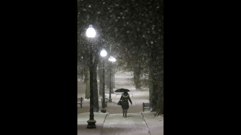 Una mujer usa un paraguas mientras camina a lo largo de un camino cubierto de nieve en el parque Boston Common, el 21 de enero.