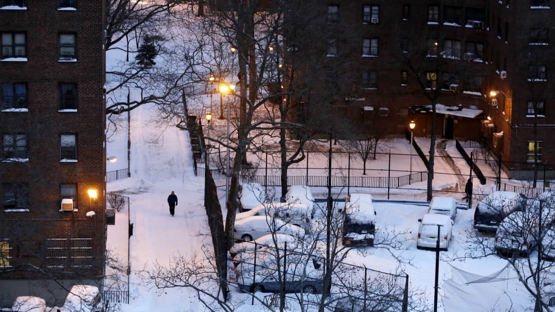 A man makes his way on a snow-covered path between apartment buildings in New York on January 22.