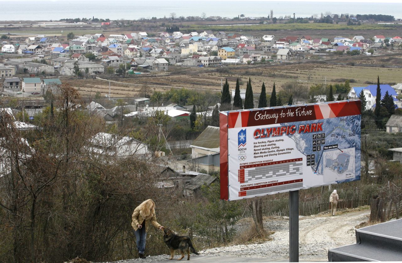 In the Imeretinskay Valley, a woman plays with a dog in February 2007, near an advertisement for the Olympic Park soon to be built in the area. Organizers of the Sochi Olympics say they want these Games to be the greenest, most environmentally aware games ever staged.   