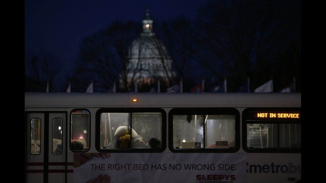 People sleep inside a Metrobus parked at Union Station in Washington on January 22. The bus was designated a warming station for the homeless.