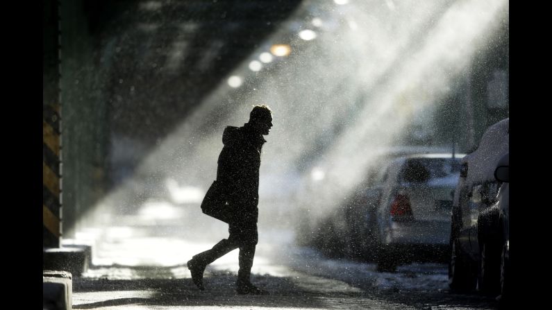 Windblown snow swirls around a man under elevated train tracks in Philadelphia on Wednesday, January 22. 
