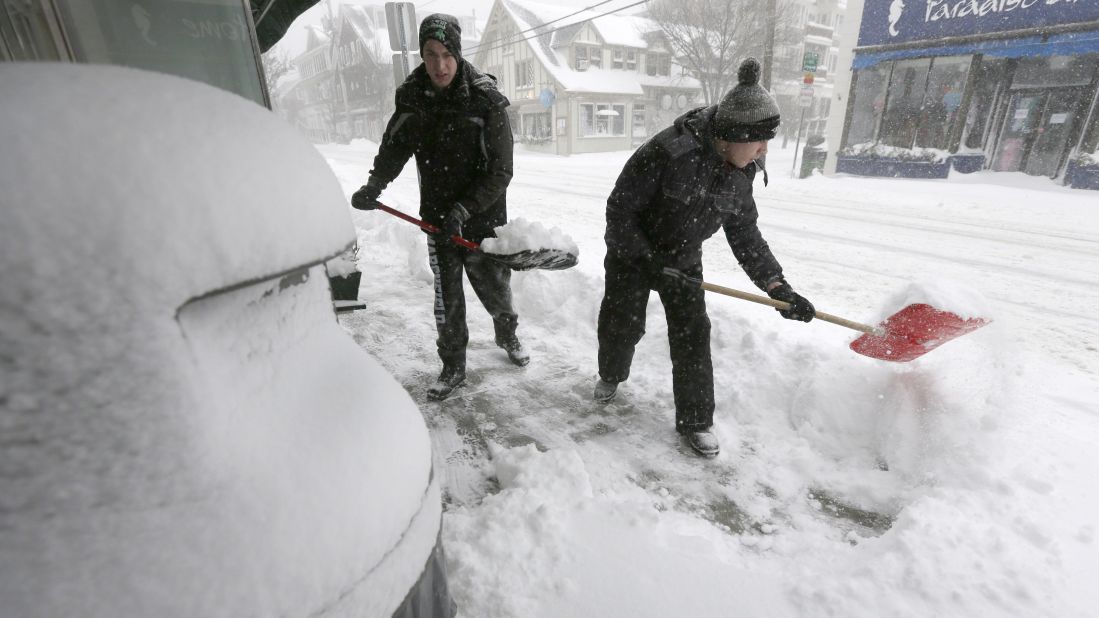 Tommy Mallios, left, and his brother Evan shovel snow from a sidewalk in Scituate, Massachusetts, on January 22.
