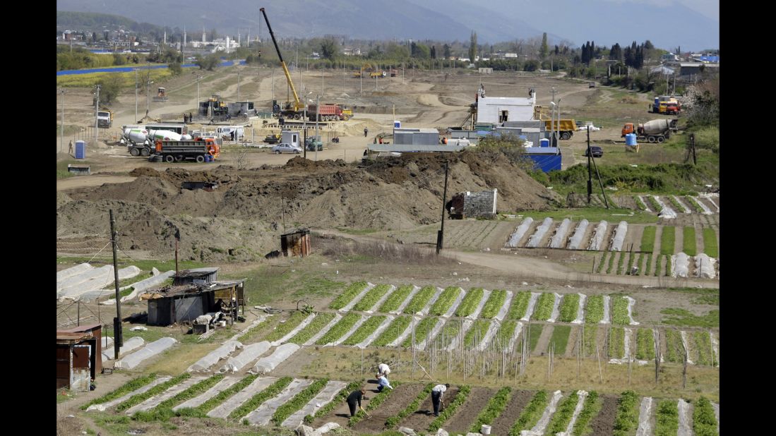 People work on their vegetable gardens near the construction site of the Olympic facilities in the Imeretinskaya Valley in April 2009.