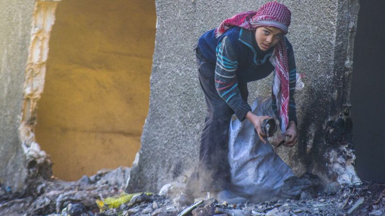 Un niño sirio recoge artículos de una pila de basura en Douma, al noreste de la capital, el sábado 18 de enero. 