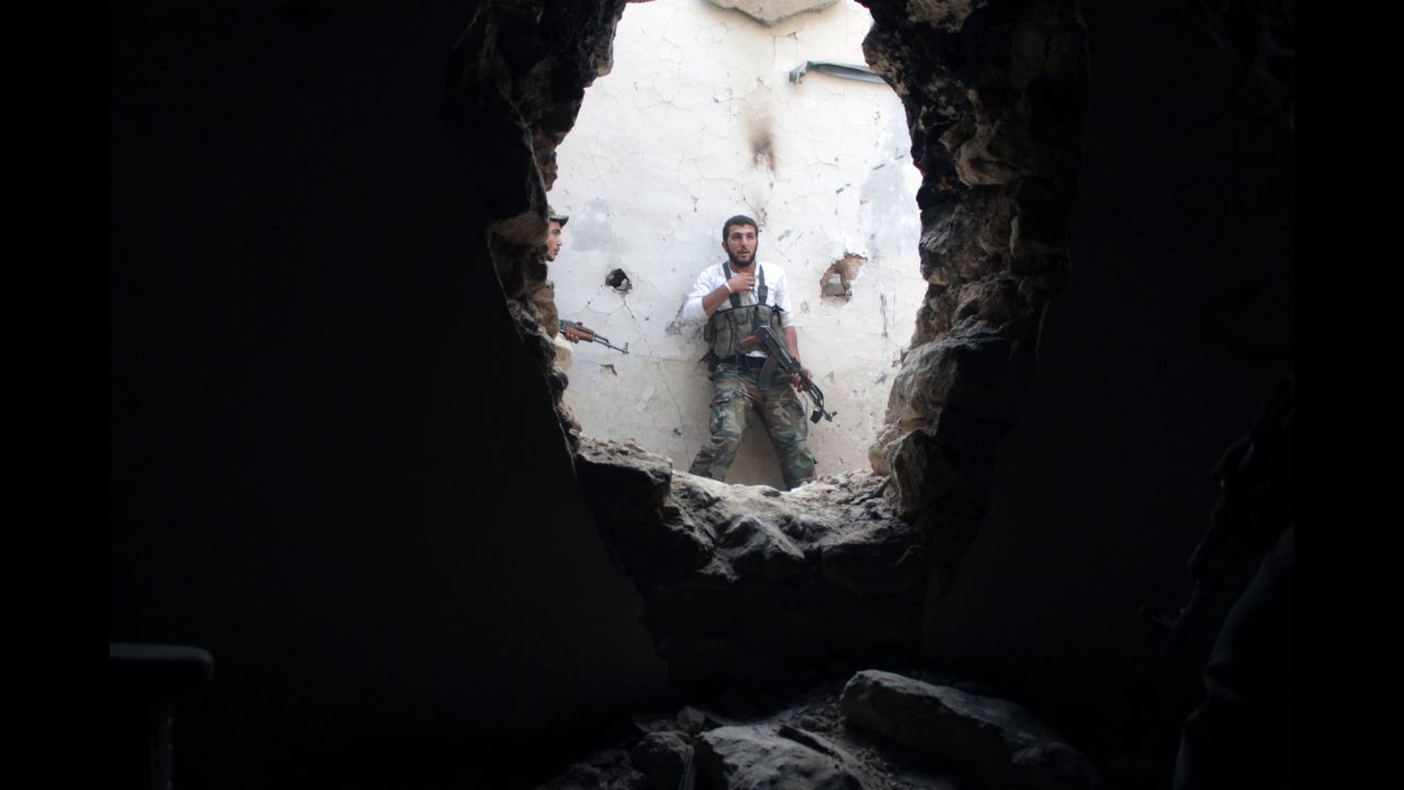 A rebel fighter holds his position in a damaged building during clashes with government forces in Deir Ezzor on Monday, November 11.