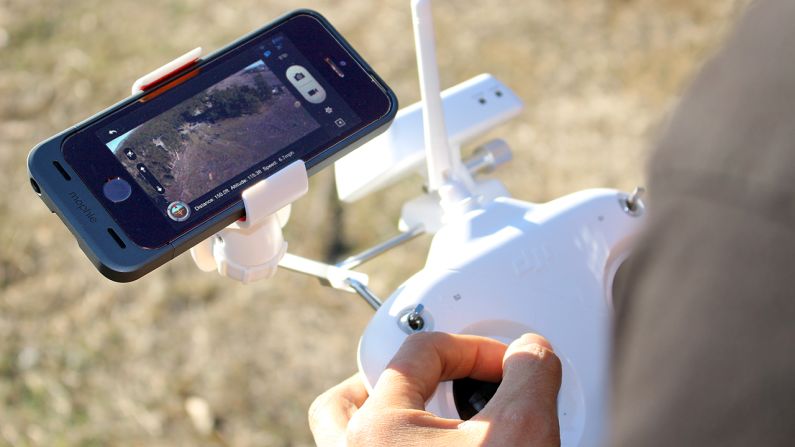 Live video from a <a href="http://www.dji.com/product/phantom/" target="_blank" target="_blank">DJI Phantom</a> drone is displayed on an iPhone app. The Phantom controller has a special mount for the smartphone. 