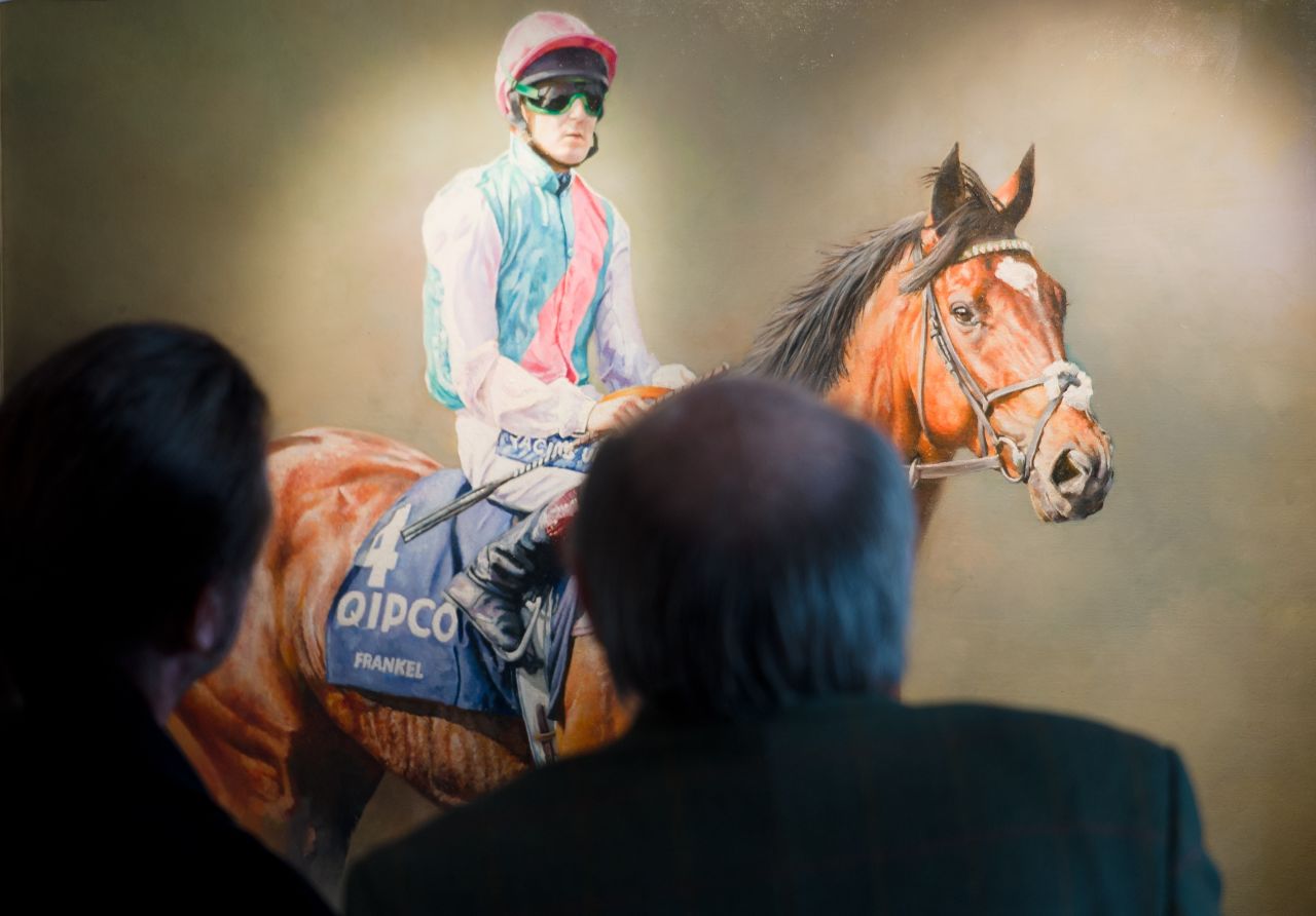 Such was his success Frankel was even immortalized in paintings. Here racegoers look at a painting of racehorse Frankel at Ascot.