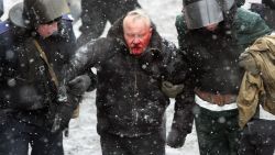 Ukrainian riot policemen detain a bleeding protester following clashes between security forces and pro-EU demonstrators in central Kiev on January 22, 2014. Five activists were killed and 300 wounded in the Ukrainian capital Kiev in a day of intense clashes with security forces, the medical centre of the protest movement said.