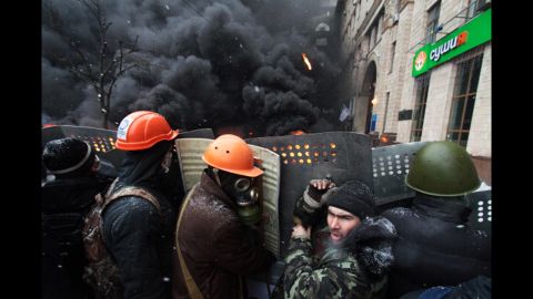 Protesters are seen in front of burning tires on Grushevsky Street.