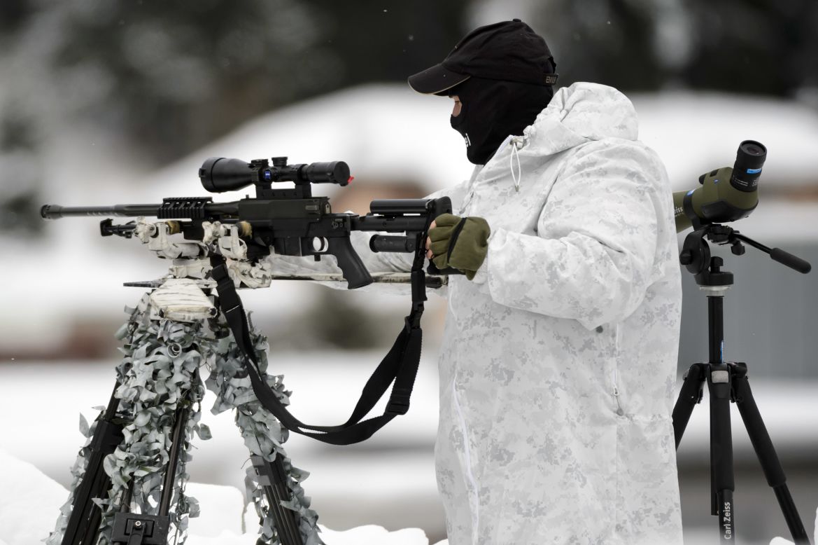 Security is key in Davos, with more than 40 heads of state attending. Pictured here is a Swiss special police sniper on the roof of the Congress Center. 