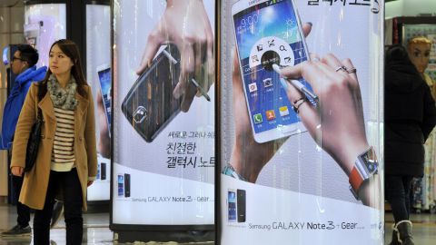 A woman in Seoul walks past signs advertising the Galaxy Note 3, the smartphone from Korean manufacturer Samsung.