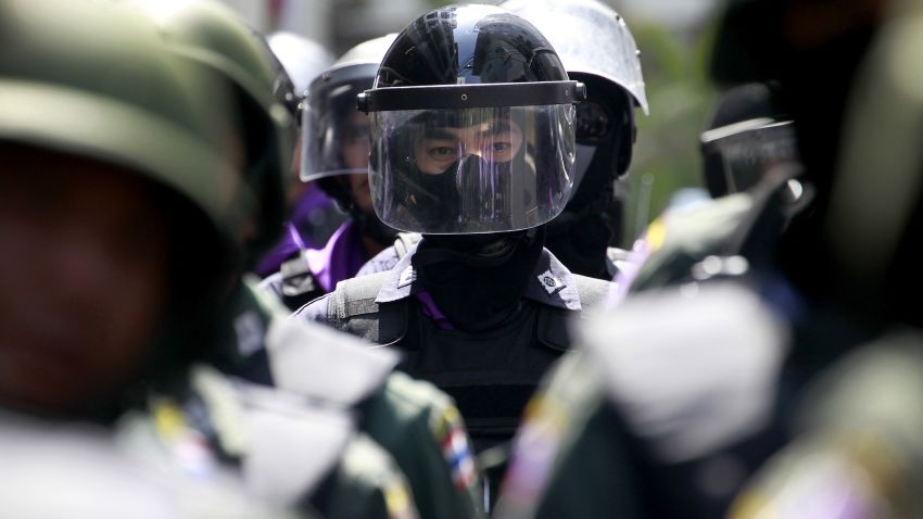Thai policemen form up a line as anti-government protesters stage a rally outside the police headquarters Wednesday, Jan. 22, 2014 in Bangkok, Thailand.