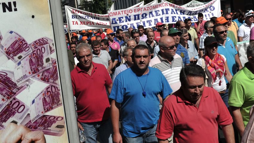 Workers at the large state-run mining and metallurgical company LARKO march by a lottery advertisement during their protest rally in ceNtral Athens on September 10, 2013 against the privatisation of the company which threatens their jobs. Greece has received massive rescue funding, tied to tough conditions, from the EU and the IMF to help it overcome a debt crisis which threatened the eurozone AFP PHOTO/ LOUISA GOULIAMAKILOUISA GOULIAMAKI/AFP/Getty Images