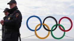 Police officers pass the logo in the olympic park opened for the 2014 Winter Olympic Games in Sochi on January 7, 2014, in Sochi, Russia.