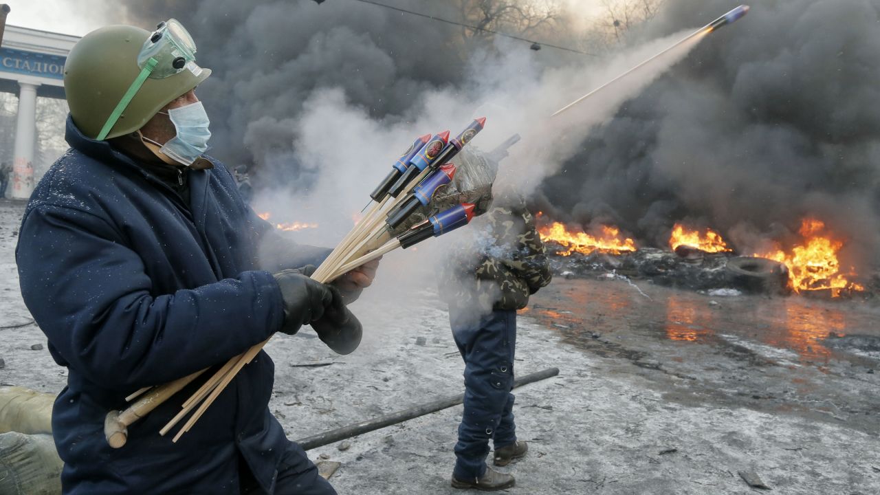 A protester shoots fireworks at police during clashes in Kiev on January 23.