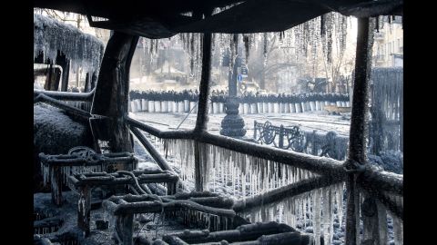 Riot police stand guard near a burnt-out bus covered in icicles in Kiev on January 23.