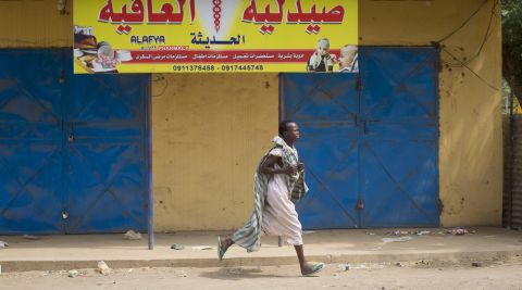 A woman runs through the street in Malakal as gunshots ring out a few streets over on January 21.