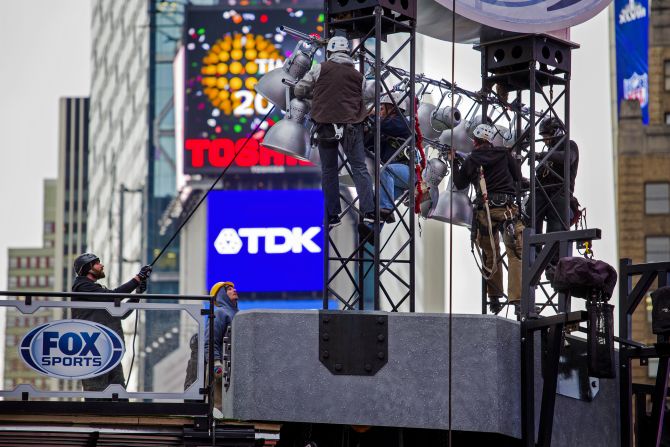 Trabajadores suben el andamiaje de una plataforma de varios niveles que se está construyendo para la cadena Fox Sports en Times Square.
