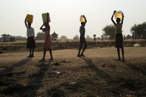 Internally displaced children carry water in Minkammen on January 10.