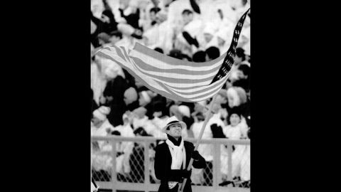 U.S. athletes at the 1988 Winter Olympics in Calgary, Alberta. Biathlete Lyle Nelson carries the flag during the opening ceremony.