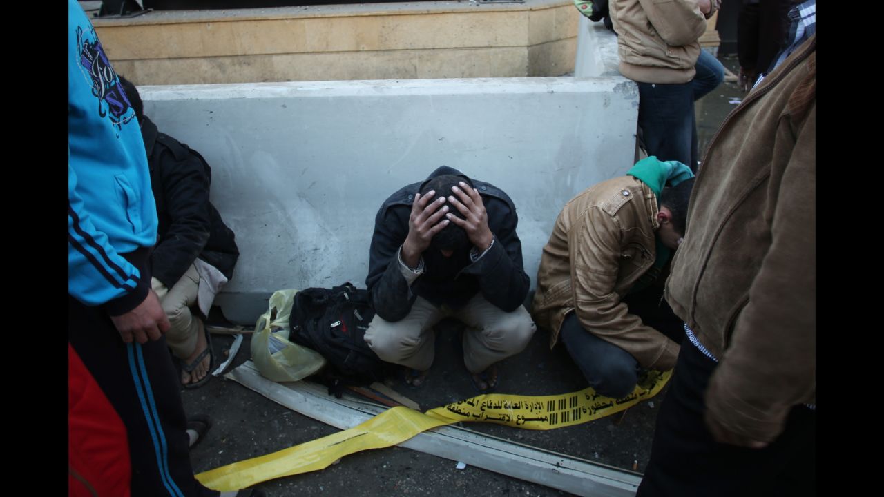 Egyptian police officers sit on the street after the blast.