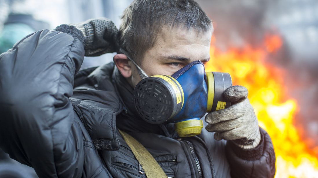 A protester puts on a gas mask near Dynamo Stadium in Kiev on January 24.