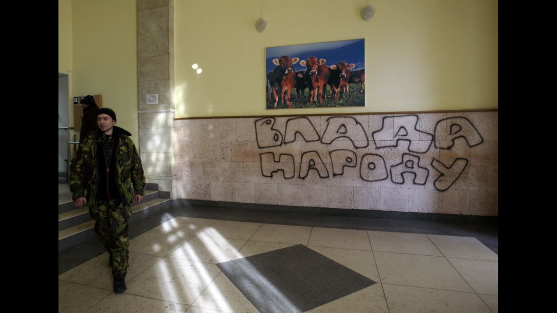 A protester passes past graffiti that reads "Government for People" in the Ministry of Agricultural Policy building in Kiev on January 24.