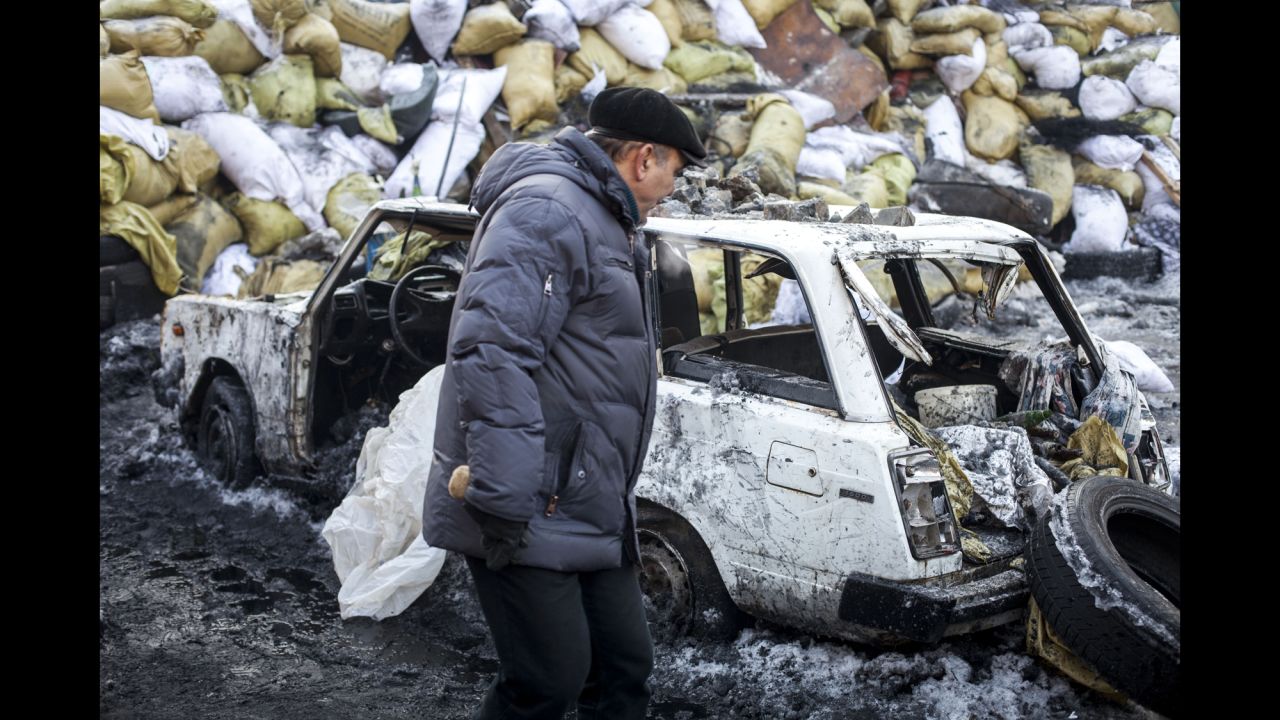 A man walks past the wreckage of a car on January 24.