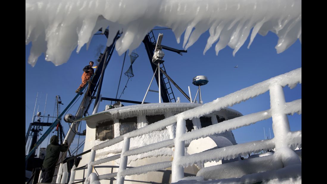 A fisherman fires up a welding torch while working on repairs to the Harmony, an ice-covered fishing trawler, in Portland, Maine, on January 23.