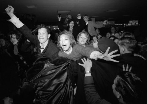 Fans de los Beatles contenidas por la policía en el aeropuerto.