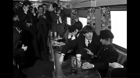 The Beatles have their pictures taken as they sit on a train taking them from New York to Washington on February 11, 1964.