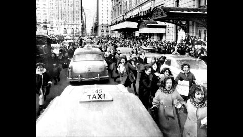 Fanáticos miran a los Beatles mientras la banda pasa por Nueva York.