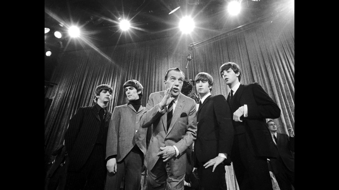 Television host Ed Sullivan, center, stands with The Beatles on February 9, 1964, during a rehearsal for the band's appearance on "The Ed Sullivan Show." The iconic television appearance remains one of the highest-rated nonsports programs of all time. Nielsen estimated that 45% of the country watched the show -- more than 73 million people then.