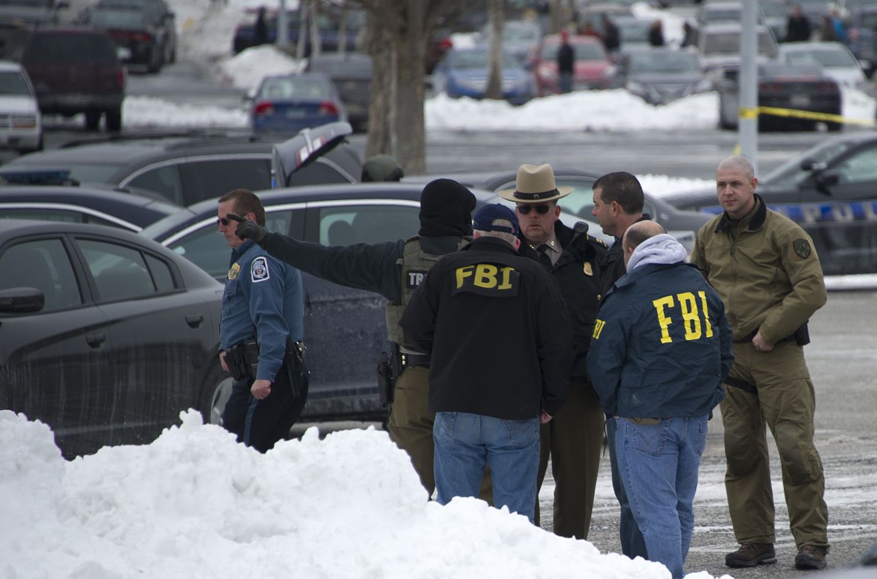 Police and FBI agents meet outside the mall. 