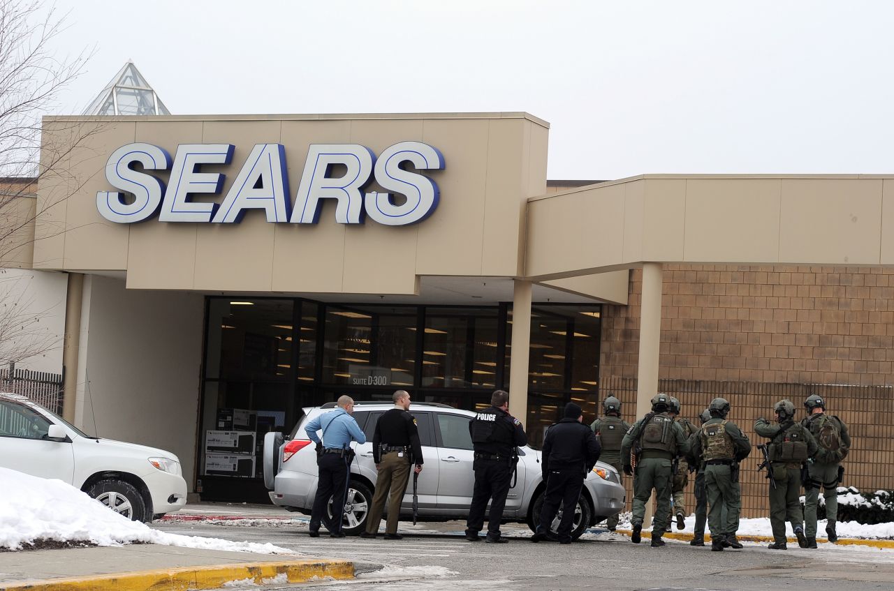 Police patrol outside a Sears store at the mall. 
