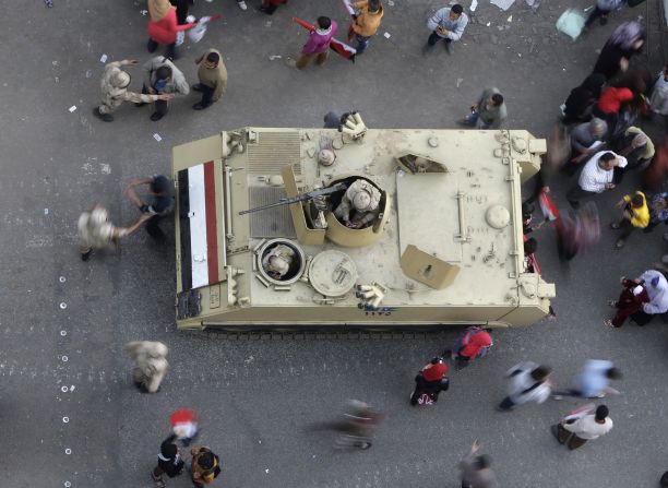 Egyptians walk around an armored personnel carrier parked at a pro-military rally in Tahrir Square. 