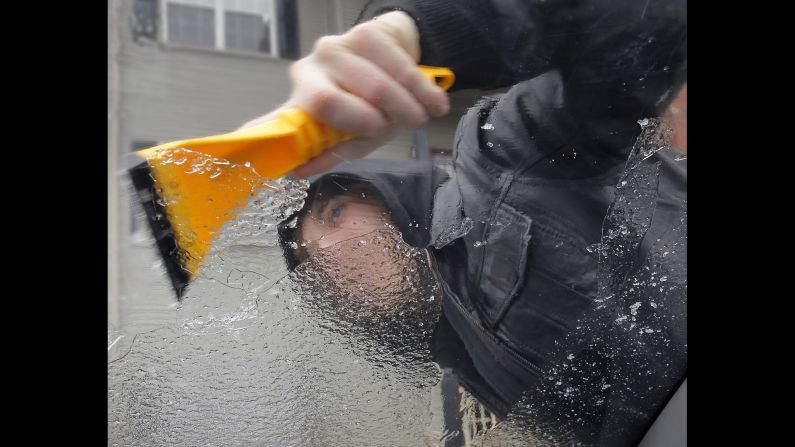 Kyle Malott scraps the ice off his girlfriend's car near Covington, Louisiana, on January 24.