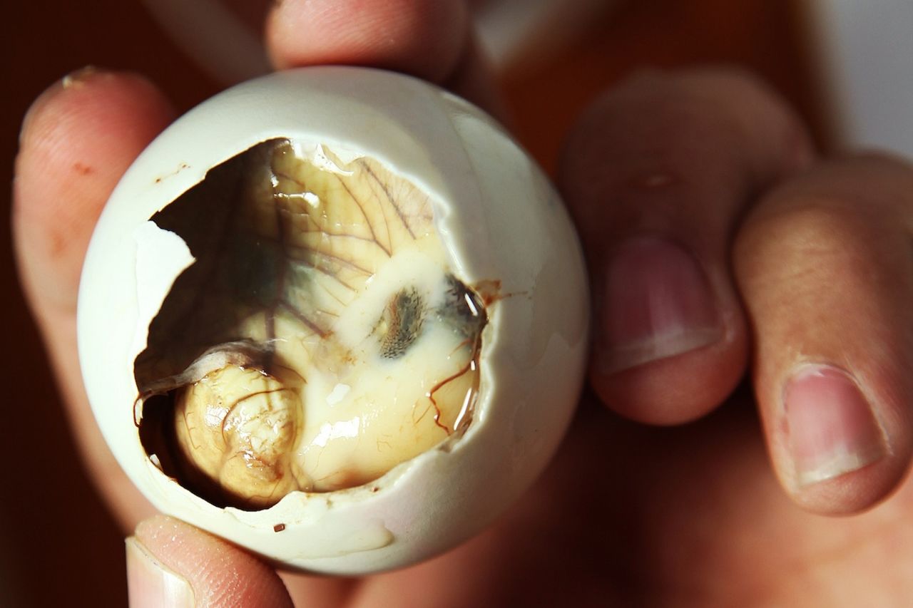 Before removing the contents of the egg, balut connoisseurs recommend drinking the warm soup within. It can be quickly slurped through the small opening you've made in the top. 
