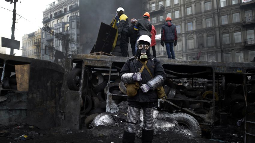 An anti-government protester, wearing a gas mask, stands at a road block in Kiev on January 26, 2014.