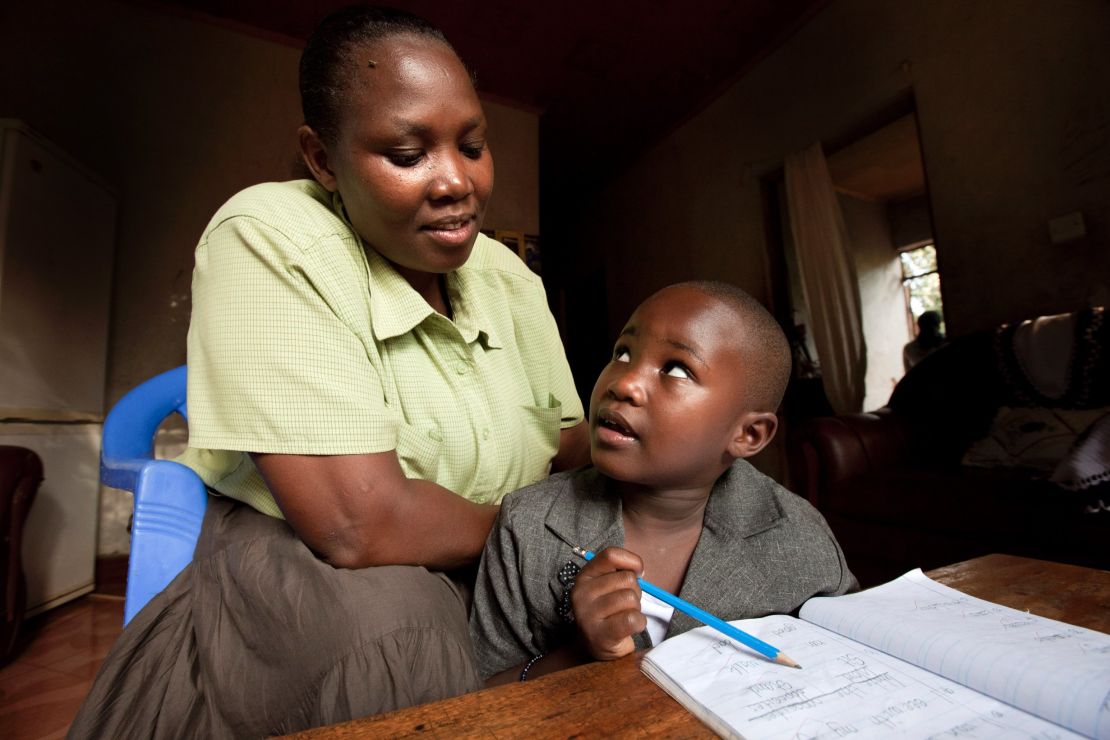 Tatu Msangi, who is HIV-positive, works on homework with virus-free daughter Faith.