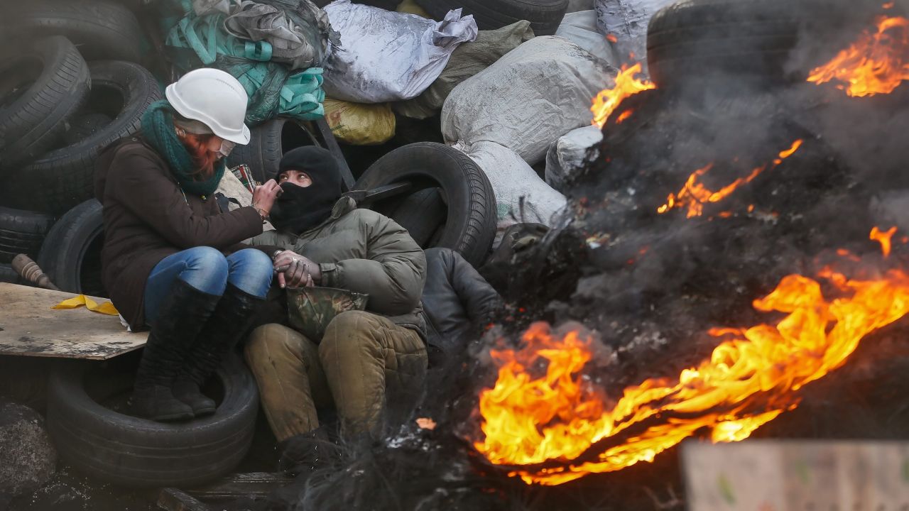 A couple try to keep warm near a fire at a barricade in Kiev on January 27.