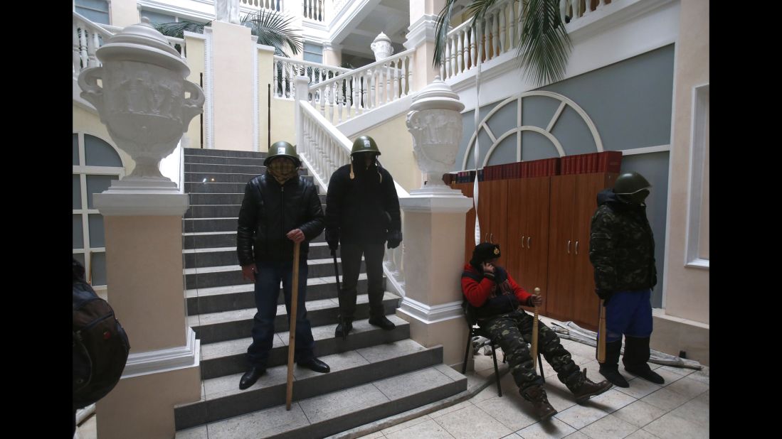 Protesters stand guard inside the Ukraine Justice Ministry in Kiev on January 27. Demonstrators later left the building because they didn't want to create any difficulties in negotiations between the government and opposition, a protest leader said. Protesters repositioned themselves outside and blocked access to the building, the leader said.