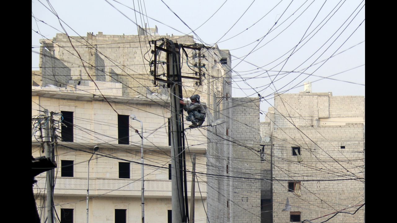 A man tries to fix electrical wires in a neighborhood of Aleppo, Syria, on January 27.