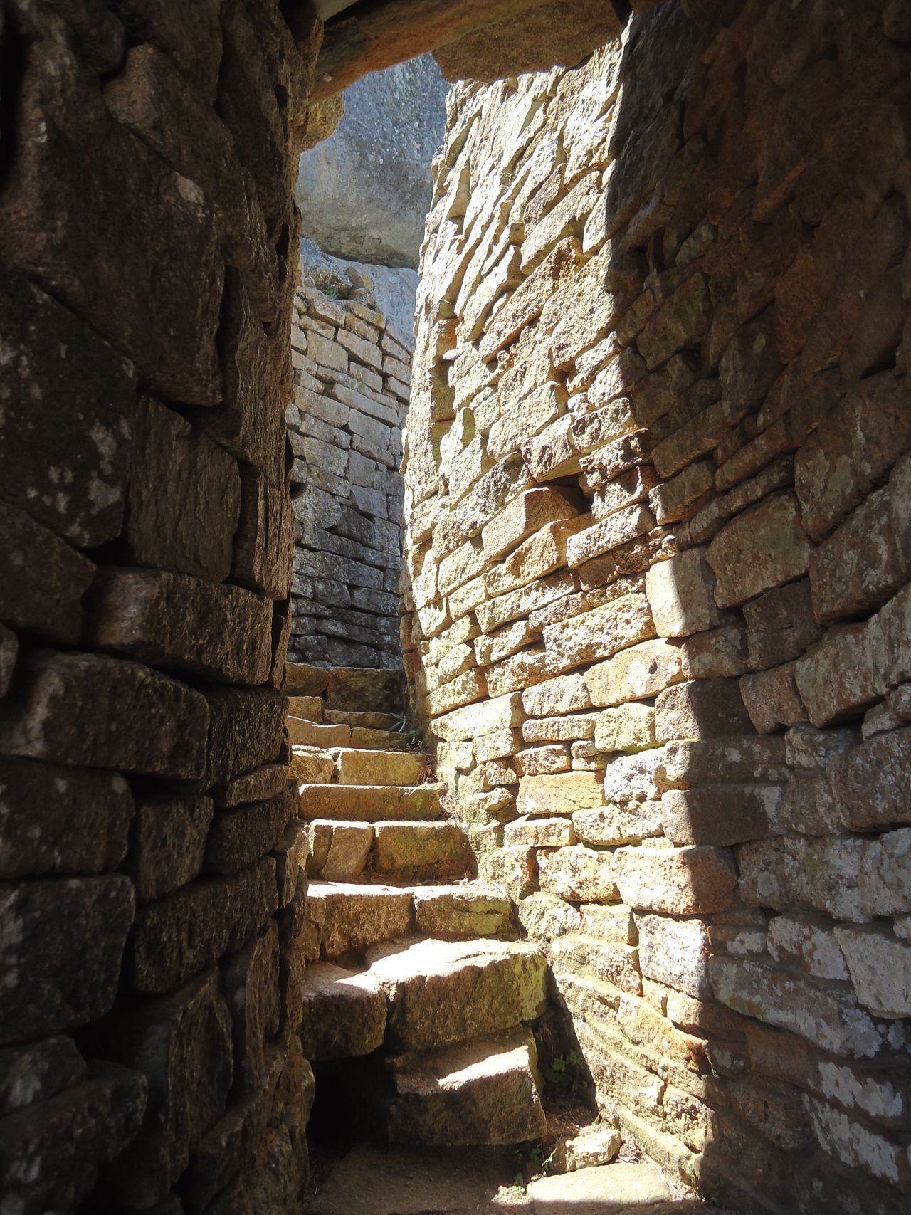 Walls extend between rocky outcrops and massive rocks, forming a maze of narrow passageways and enclosures.