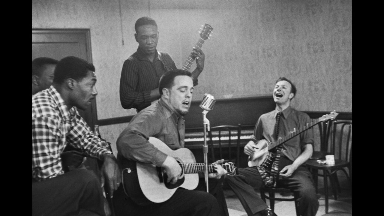 Musician Alan Lomax, center, and Seeger sing and play instruments as they practice for a concert in 1959.