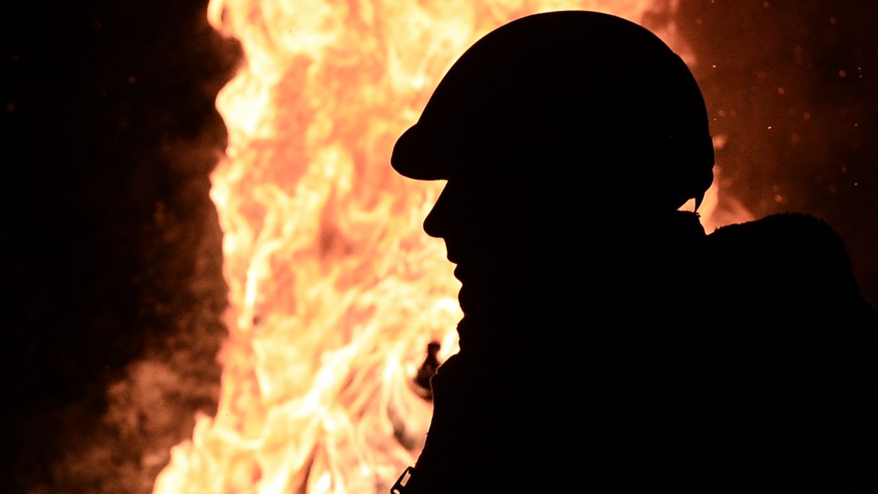 An anti-government protester stand next to a fire to get warm at a road block in Kiev on January 26, 2014.