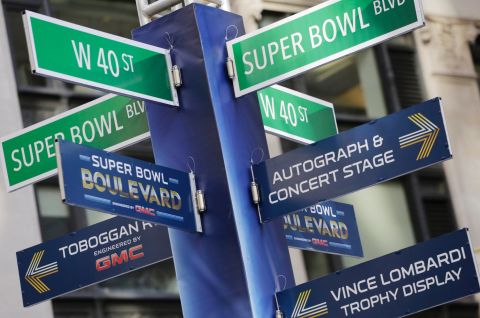 Street signs point to Super Bowl attractions in Times Square. Several blocks of Manhattan have been converted into a temporary festival space.