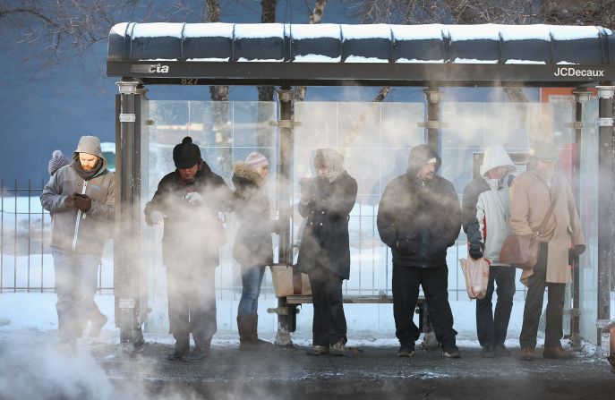 With temperatures around -10 degrees, commuters wait for a bus in Chicago on January 27.