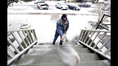 A man puts sand on the steps of his business in downtown Northport, Alabama, on January 28. Northport is near Tuscaloosa in the central-west part of the state.